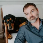 Oleg, CEO and co-founder of AkiByte, sitting with his dog and representing the company’s creative leadership.