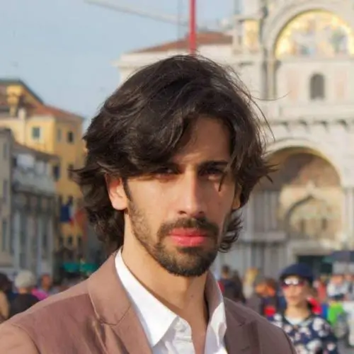 Alexandre, Design Director von AkiByte, steht im Freien vor architektonischer Kulisse