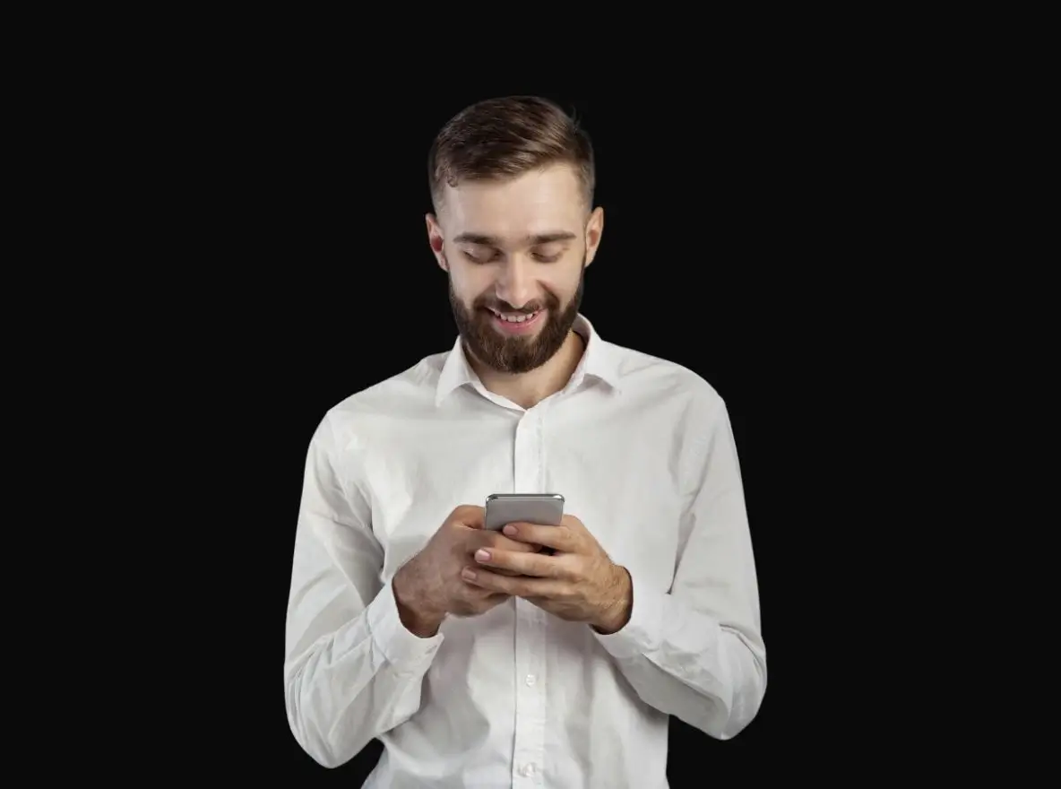 Mann nutzt Smartphone vor schwarzem Hintergrund, Schwerpunkt auf ablenkungsfreiem Dark-Mode-UI-Testing und Nutzererlebnis