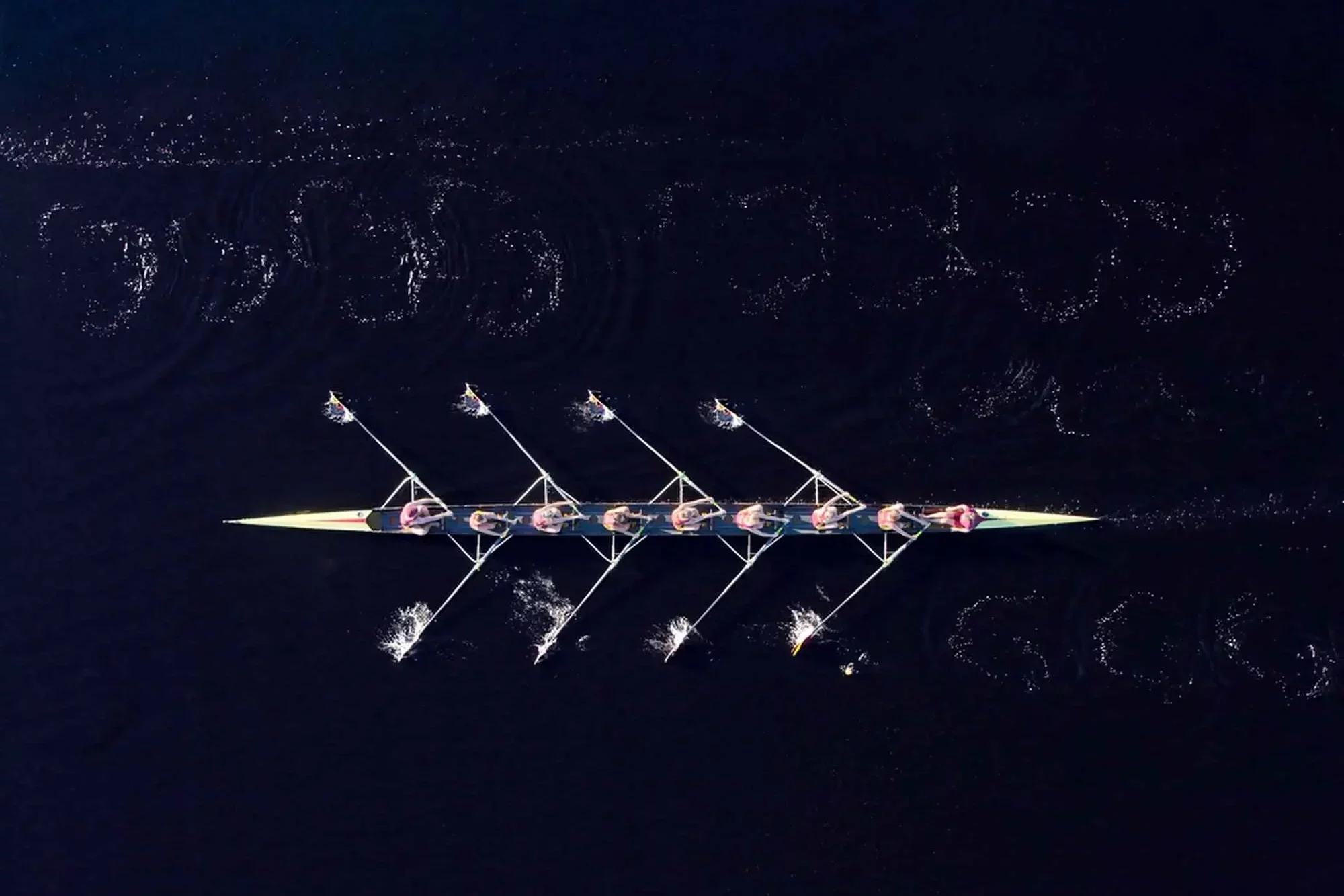 Luftaufnahme eines Ruderteams, das AkiBytes Teamarbeit, Strategie und Präzision bei digitalen und Webautomatisierungsprojekten symbolisiert