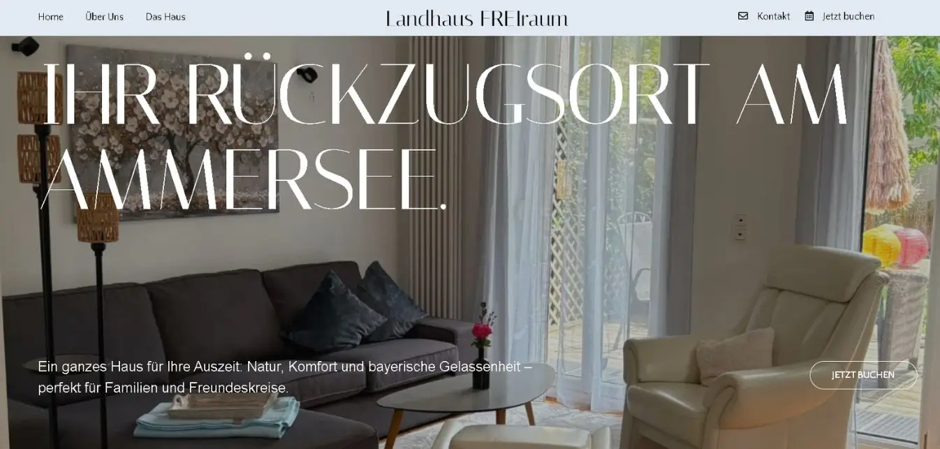 Wohnbereich im Landhaus Freiraum am Ammersee mit Sofa, Sessel und großem Fenster zur Terrasse