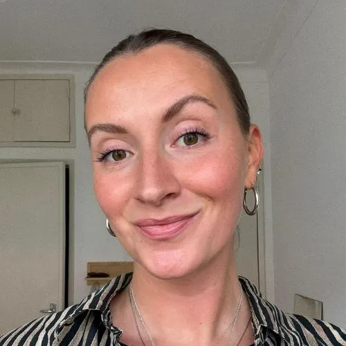 Bella, AkiByte SEO Expertin und Content Editor l&auml;chelt in hellem Raum in die Kamera