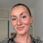Bella, AkiByte SEO Expertin und Content Editor lächelt in hellem Raum in die Kamera