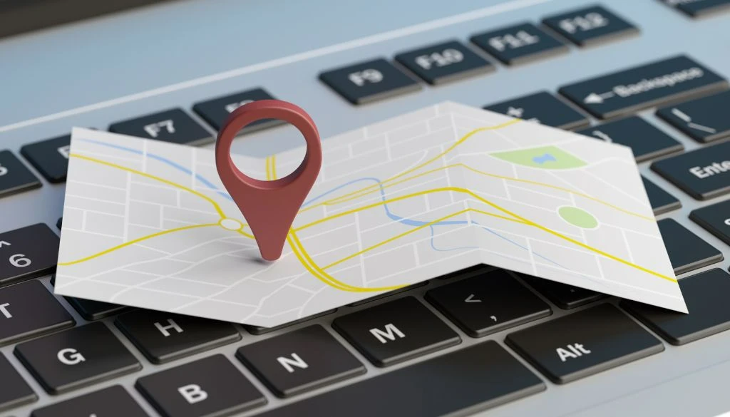 Google Maps Navigation mit Standort-Pin auf digitaler Karte auf einer Laptop-Tastatur