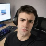 Ismael, AkiByte Social Media Manager mit Kopfhörern am Arbeitsplatz vor Computer